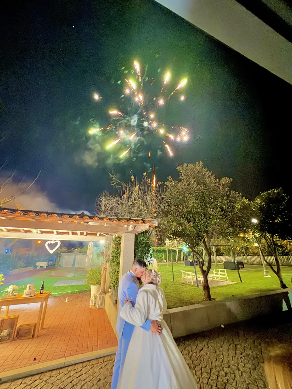 Fogo de artifício sobre os noivos no jardim
